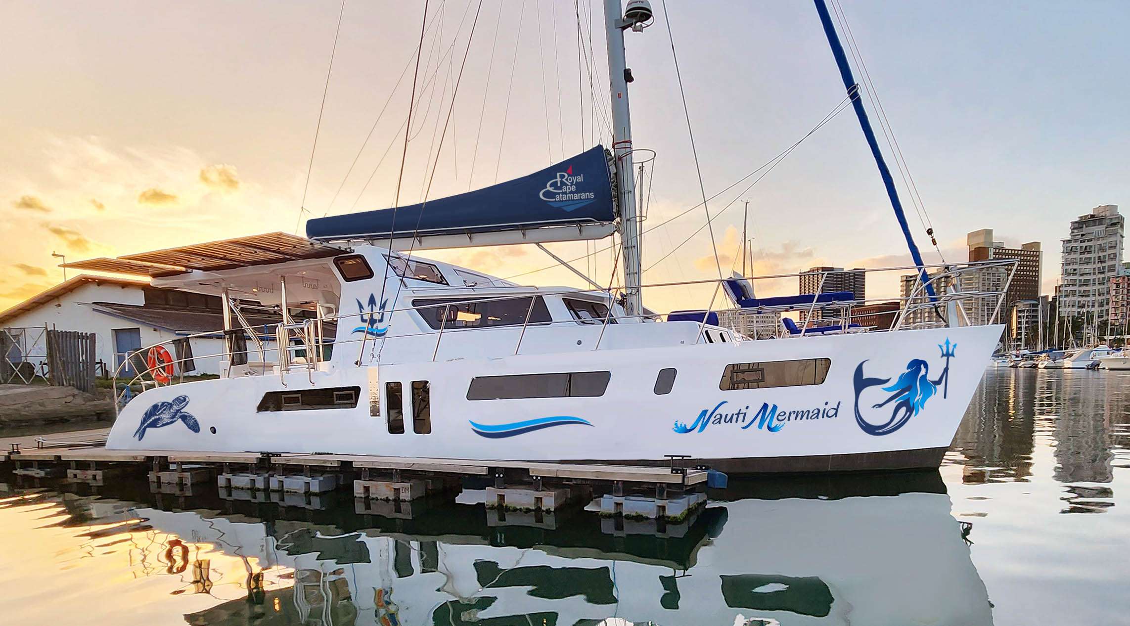 Step aboard the Nauti Mermaid, a stunning Royal Cape Majestic 530 hybrid catamaran designed to whisk you away on an unforgettable adventure at sea. With its sleek, modern design, abundant natural light, and superior ventilation, this luxurious floating haven sets the stage for a vacation you’ll never want to end.

From the moment you step on board, you'll be welcomed by spacious three-foot walkways, ample headroom, and uncluttered decks—perfect for strolling, sunbathing, and taking in the breathtaking views. Inside, the open-concept salon, well-appointed galley, and elegantly designed cabins offer the perfect blend of comfort and style, each thoughtfully equipped with TVs, excellent lighting, and both AC and DC power sources to keep you connected and relaxed.

***Photos in this brochure of the vessel are stock photos. Decor of the vessel may vary***

Love the outdoors? The expansive solid bimini over the cockpit provides plenty of shade, while built-in lounges on the foredeck and movable lounge chairs invite you to unwind in the warm ocean breeze. Sip a glass of chilled wine from the onboard wine cooler as you toast to another perfect day under the tropical sky. With 6,000 watts of solar panels powering multiple freezers, refrigerators, and even a trash compactor, the Nauti Mermaid delivers eco-friendly luxury at its finest.

Your days can be as adventurous or as laid-back as you choose. Ride the waves with the wakeboard, foiling board, and kneeboard, or explore underwater wonders with snorkel gear, underwater sleds, and a crystal-clear kayak or canoe. Hop aboard the 50HP dinghy, playfully named Nacho Boat, to visit hidden coves or lively beach bars—she comfortably seats eight for group excursions. Fishing enthusiasts will love the onboard spinning and trolling gear, while thrill-seekers can take on the subwing, scurf board, and more. Prefer a bit of friendly competition? Enjoy beach games, water guns, a floating mat, or a match of Spike Ball. There’s something for every guest, no matter the mood.

Evenings are pure magic on the Nauti Mermaid. Relax in hammocks on the stern, take a dip under the glow of underwater lights for a midnight swim, or stay connected with Starlink wireless internet—whether to share your adventures in real time or unwind with a favorite movie on the digital projector and screen. At the end of the day, retreat to your private cabin, where king and queen accommodations offer a restful night’s sleep, lulled by the gentle sway of the sea.

Guiding your journey, the Nauti Mermaid’s licensed captain navigates to the most spectacular destinations, while an accomplished chef delights you with gourmet meals tailored to your tastes. Whether you crave a romantic candlelit dinner, a lively family-style feast, or refreshing snacks between water sports, every dish is crafted to perfection.

So come experience the magic of the Nauti Mermaid—where luxury, adventure, and relaxation blend seamlessly for the ultimate getaway. With its captivating charm, premium amenities, and endless opportunities for fun, this catamaran offers an unforgettable vacation you’ll want to return to year after year.

Book your voyage today and embark on the adventure of a lifetime!

***Photos in this brochure of the vessel are stock photos. Decor of the vessel may vary***